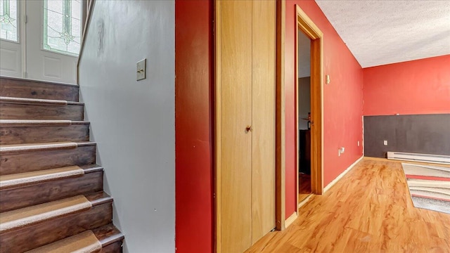 838 Cayuga Way, Stroudsburg, PA 18360 - stairway with wood finished floors, a textured ceiling, and a baseboard heating unit