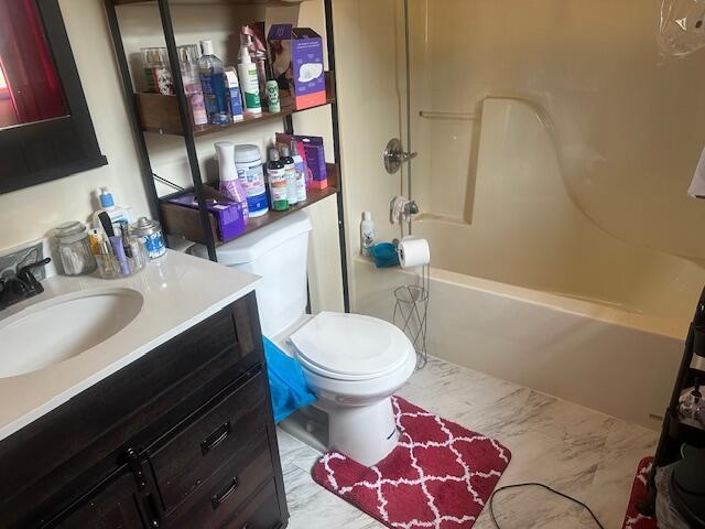 bathroom with vanity, toilet, bathtub / shower combination, and marble finish floor