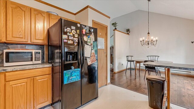 838 Cayuga Way, Stroudsburg, PA 18360 - kitchen with black fridge with ice dispenser, white microwave, a chandelier, lofted ceiling, and pendant lighting