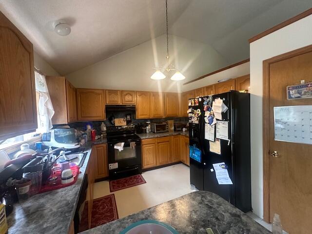 kitchen with lofted ceiling, hanging light fixtures, decorative backsplash, and black appliances
