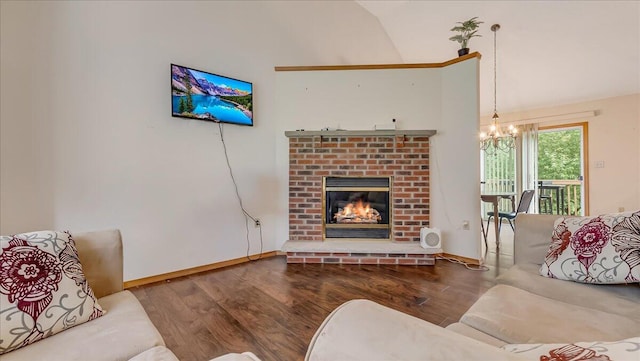 838 Cayuga Way, Stroudsburg, PA 18360 - living area with a chandelier, wood finished floors, vaulted ceiling, and a brick fireplace