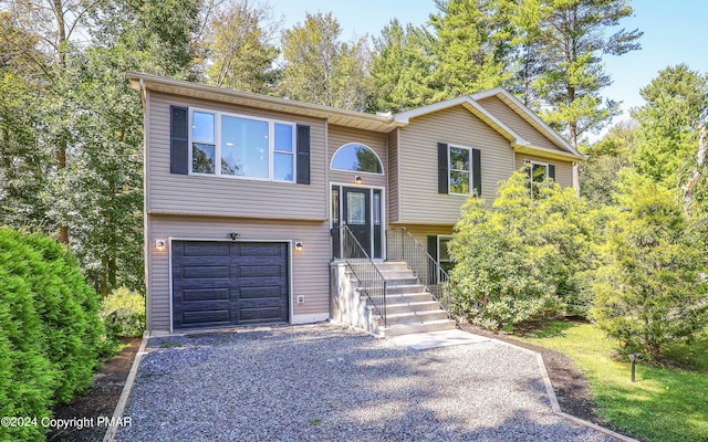 raised ranch featuring driveway and an attached garage