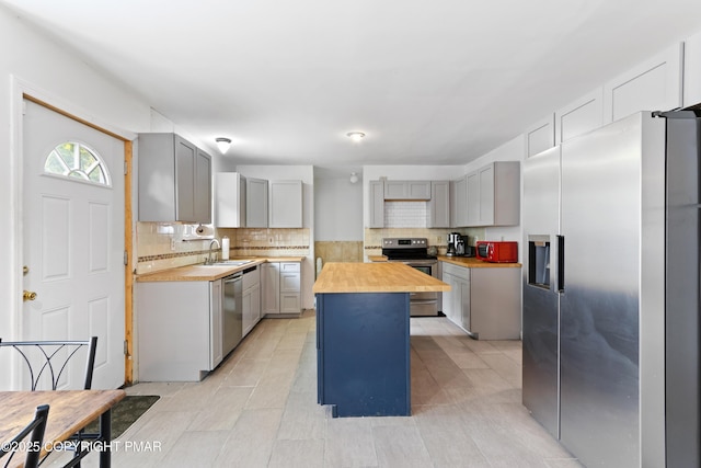 2247 Reo Dr, Effort, PA 18330 - kitchen with butcher block counters, stainless steel appliances, backsplash, gray cabinetry, and a center island