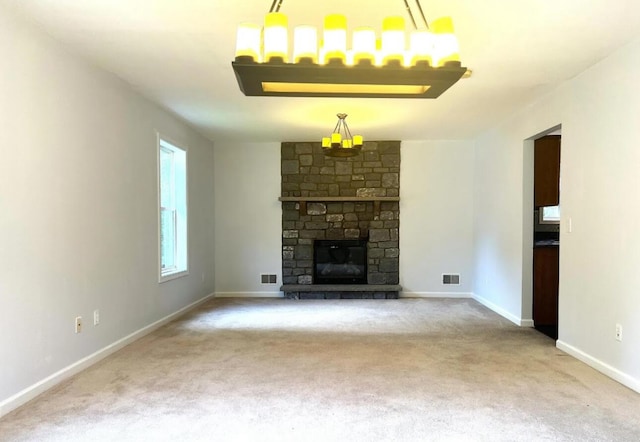 unfurnished living room with visible vents, baseboards, carpet, and a fireplace