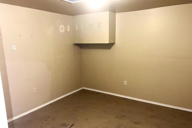 unfurnished room with baseboards and concrete floors