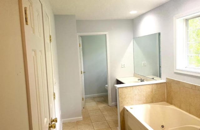 bathroom with baseboards, toilet, a whirlpool tub, tile patterned floors, and vanity