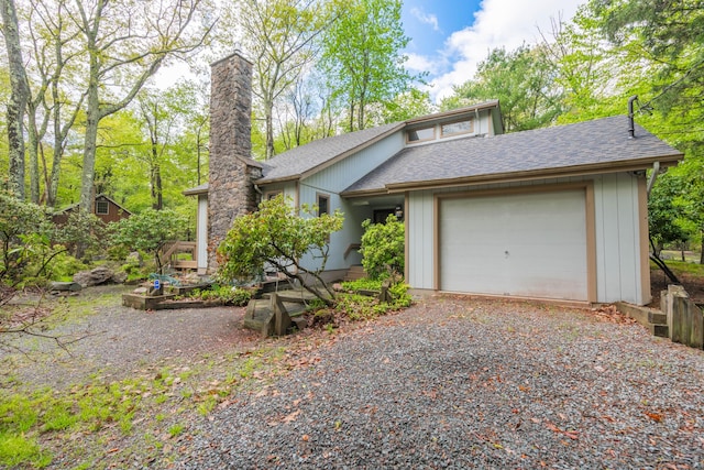 65 Maplewood Rd, Lake Harmony, PA 18624 - mid-century modern home with a shingled roof, an attached garage, a chimney, and gravel driveway