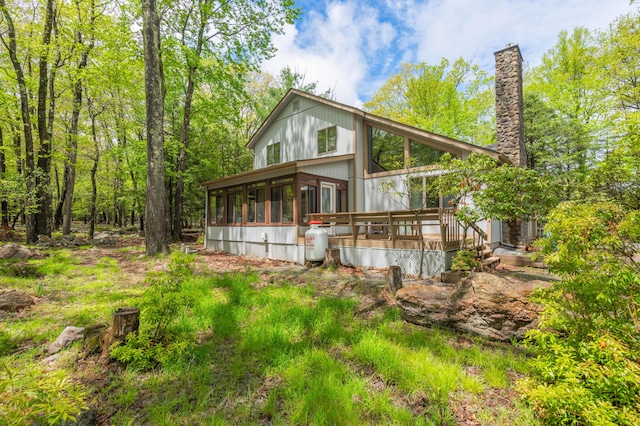 65 Maplewood Rd, Lake Harmony, PA 18624 - back of house featuring a sunroom, a wooden deck, and a chimney