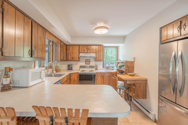 65 Maplewood Rd, Lake Harmony, PA 18624 - kitchen with white appliances, a sink, under cabinet range hood, a baseboard heating unit, and light countertops