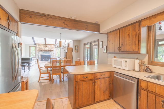 65 Maplewood Rd, Lake Harmony, PA 18624 - kitchen with appliances with stainless steel finishes, a peninsula, brown cabinets, light countertops, and beam ceiling