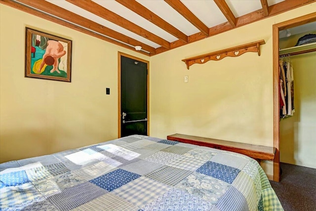 carpeted bedroom featuring beamed ceiling