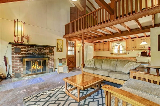 carpeted living area with a towering ceiling and a brick fireplace