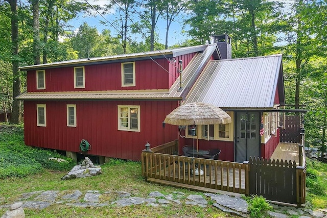 rear view of property with a chimney and metal roof