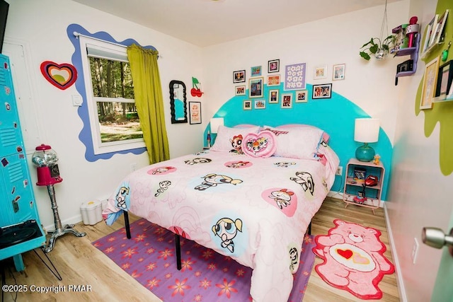 bedroom with baseboards and wood finished floors