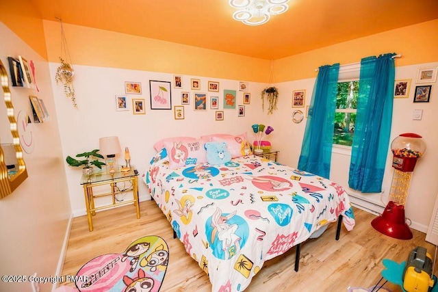 bedroom featuring wood finished floors and baseboards