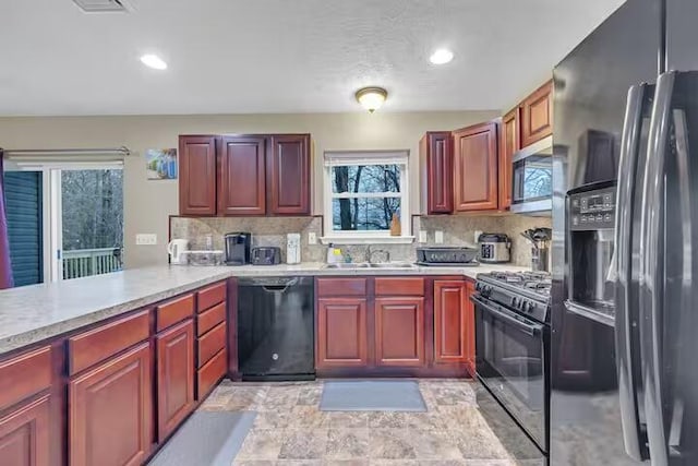 7075 Boulder Ct, Tobyhanna, PA 18466 - kitchen with black appliances, light countertops, a sink, backsplash, and recessed lighting