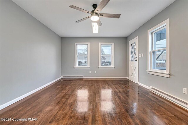 unfurnished room with baseboards, ceiling fan, baseboard heating, and wood finished floors