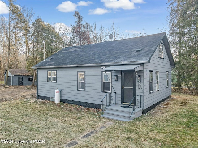 view of front of house featuring a shingled roof and a front yard