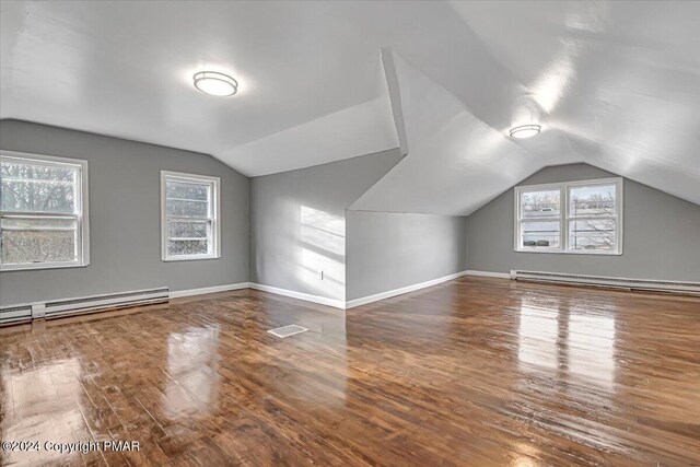 bonus room with baseboard heating, wood finished floors, and a wealth of natural light