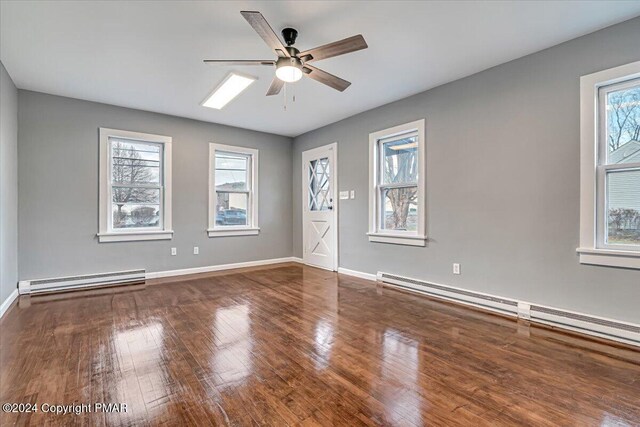 unfurnished room featuring a baseboard radiator, baseboards, and wood-type flooring