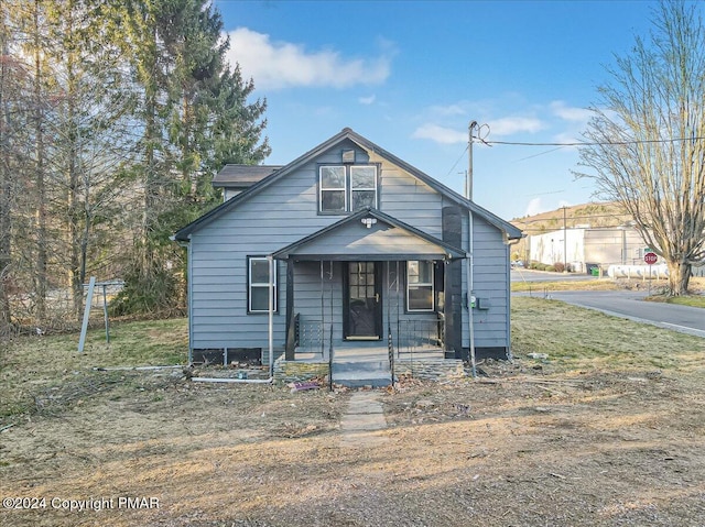 bungalow-style home with a porch and fence