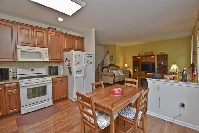 1785 Big Ridge Dr, East Stroudsburg, PA 18302 - kitchen with white appliances, light wood finished floors, tasteful backsplash, open floor plan, and brown cabinets
