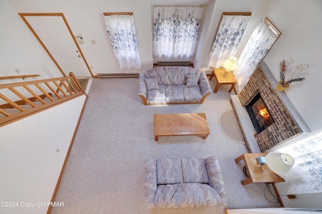 living room featuring a baseboard heating unit, a fireplace, carpet floors, and stairs