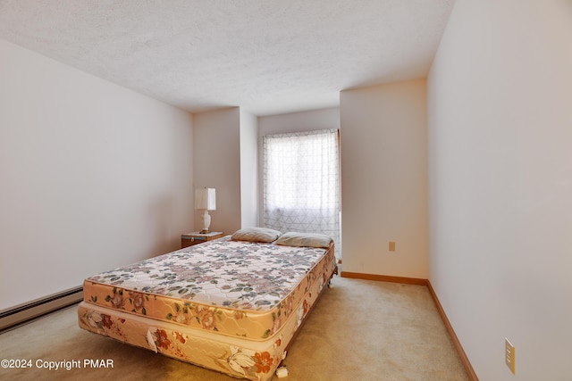 bedroom featuring a baseboard heating unit, light colored carpet, a textured ceiling, and baseboards