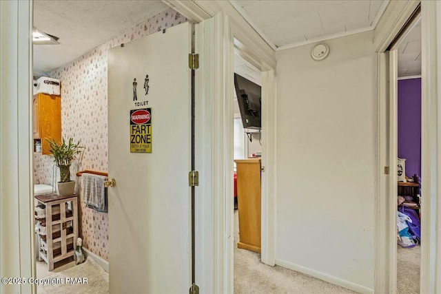 corridor with light colored carpet, baseboards, and wallpapered walls