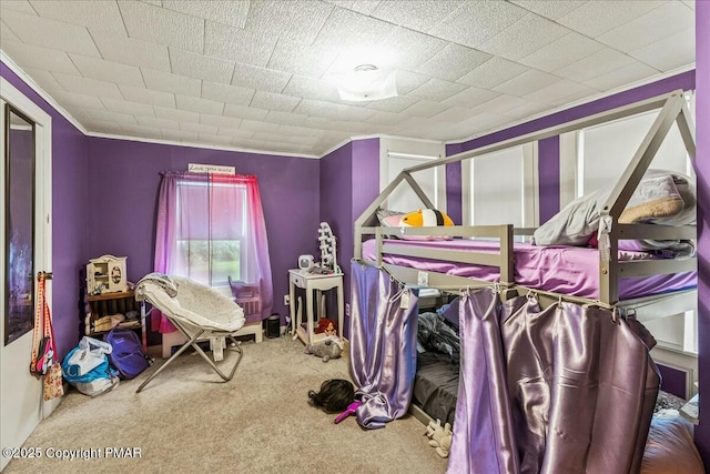 bedroom with ornamental molding and carpet flooring