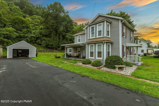 view of front of property featuring a garage, an outdoor structure, and a front yard