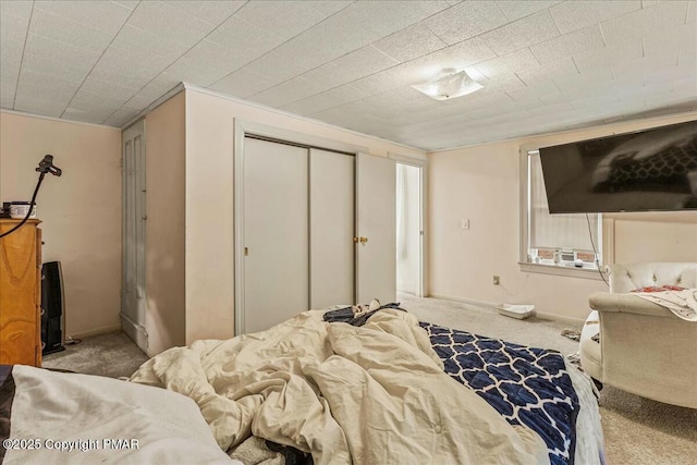 bedroom with carpet, baseboards, and a closet