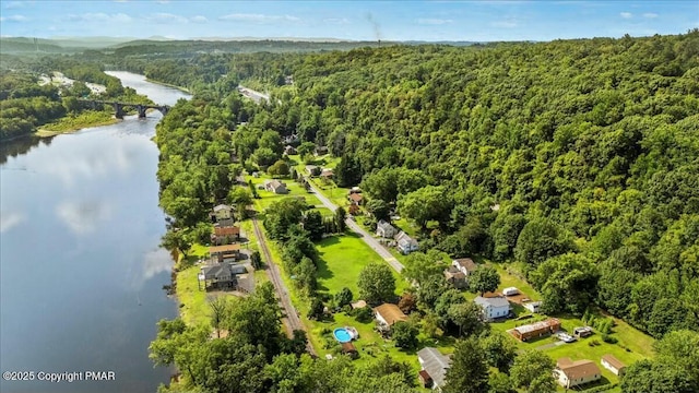 birds eye view of property with a water view and a wooded view