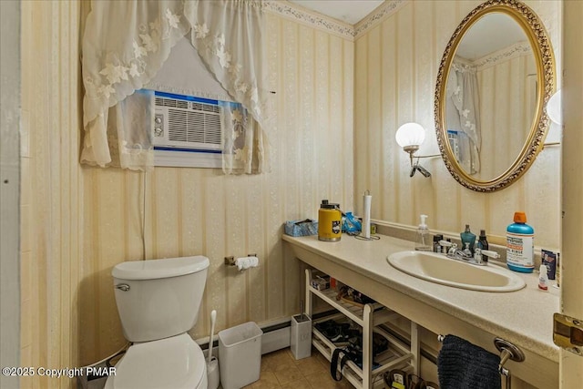 bathroom featuring wallpapered walls, toilet, tile patterned floors, vanity, and a baseboard heating unit