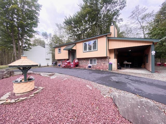 1293 Winding Way, Tobyhanna, PA 18466 - view of front facade featuring a chimney, brick siding, and asphalt driveway