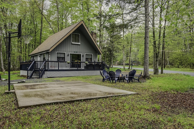 268 Outer Dr, Pocono Lake, PA 18347 - rear view of property featuring a chimney, a deck, a lawn, and board and batten siding