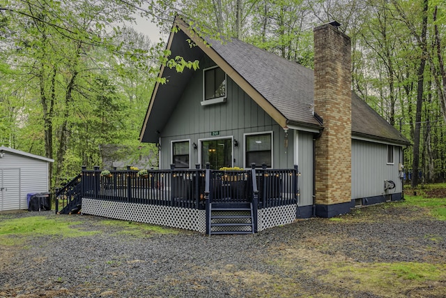 268 Outer Dr, Pocono Lake, PA 18347 - view of front of home featuring a shingled roof, a chimney, board and batten siding, and a wooden deck
