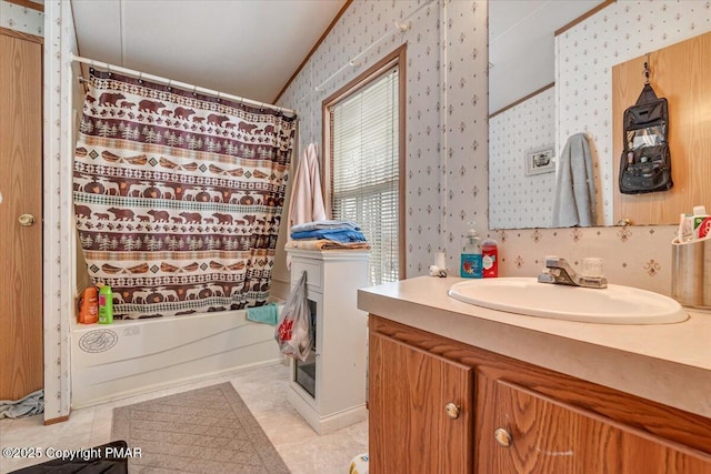 bathroom with wallpapered walls, shower / tub combo with curtain, and vanity