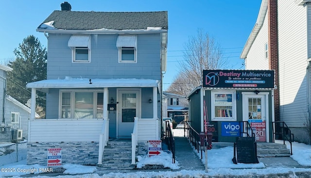 view of front of property with a porch and roof with shingles