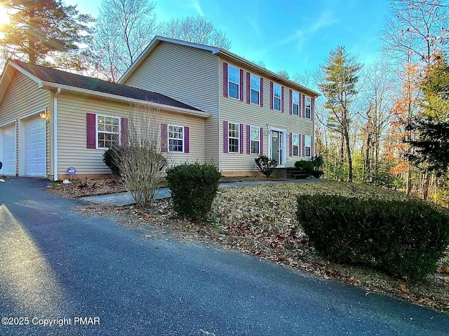 colonial inspired home featuring a garage and driveway