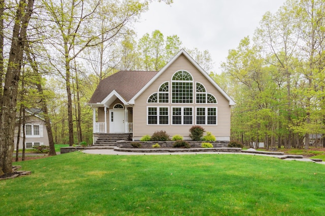 view of front of property featuring a front lawn and a shingled roof