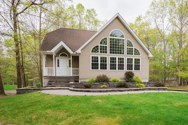 view of front of home featuring a front yard and a shingled roof