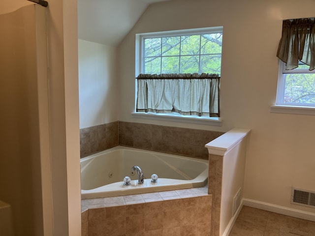 bathroom with a whirlpool tub, lofted ceiling, tile patterned floors, and baseboards
