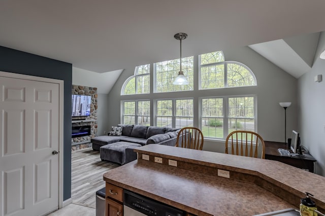 kitchen with vaulted ceiling, hanging light fixtures, and open floor plan