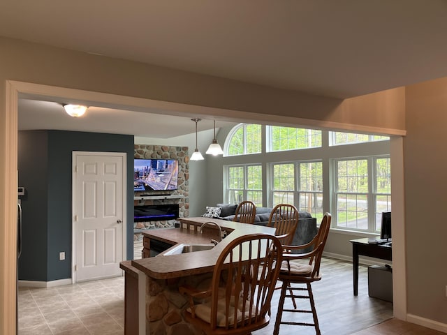 dining area with baseboards and a fireplace