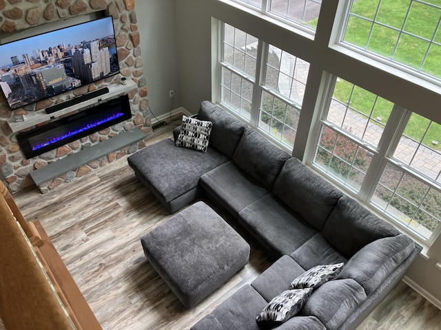 living area with wood finished floors, healthy amount of natural light, a fireplace, and baseboards