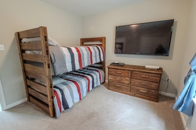 bedroom featuring light carpet and baseboards