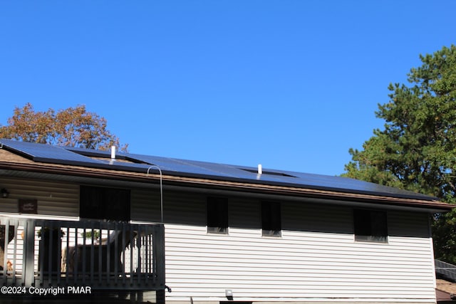 view of home's exterior featuring covered porch and roof mounted solar panels