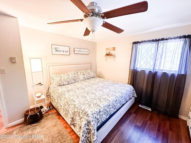 bedroom featuring baseboards, a ceiling fan, and wood finished floors