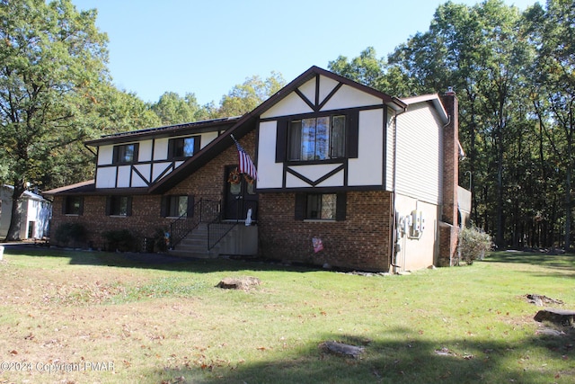 tudor house with stucco siding, a chimney, a front lawn, and brick siding